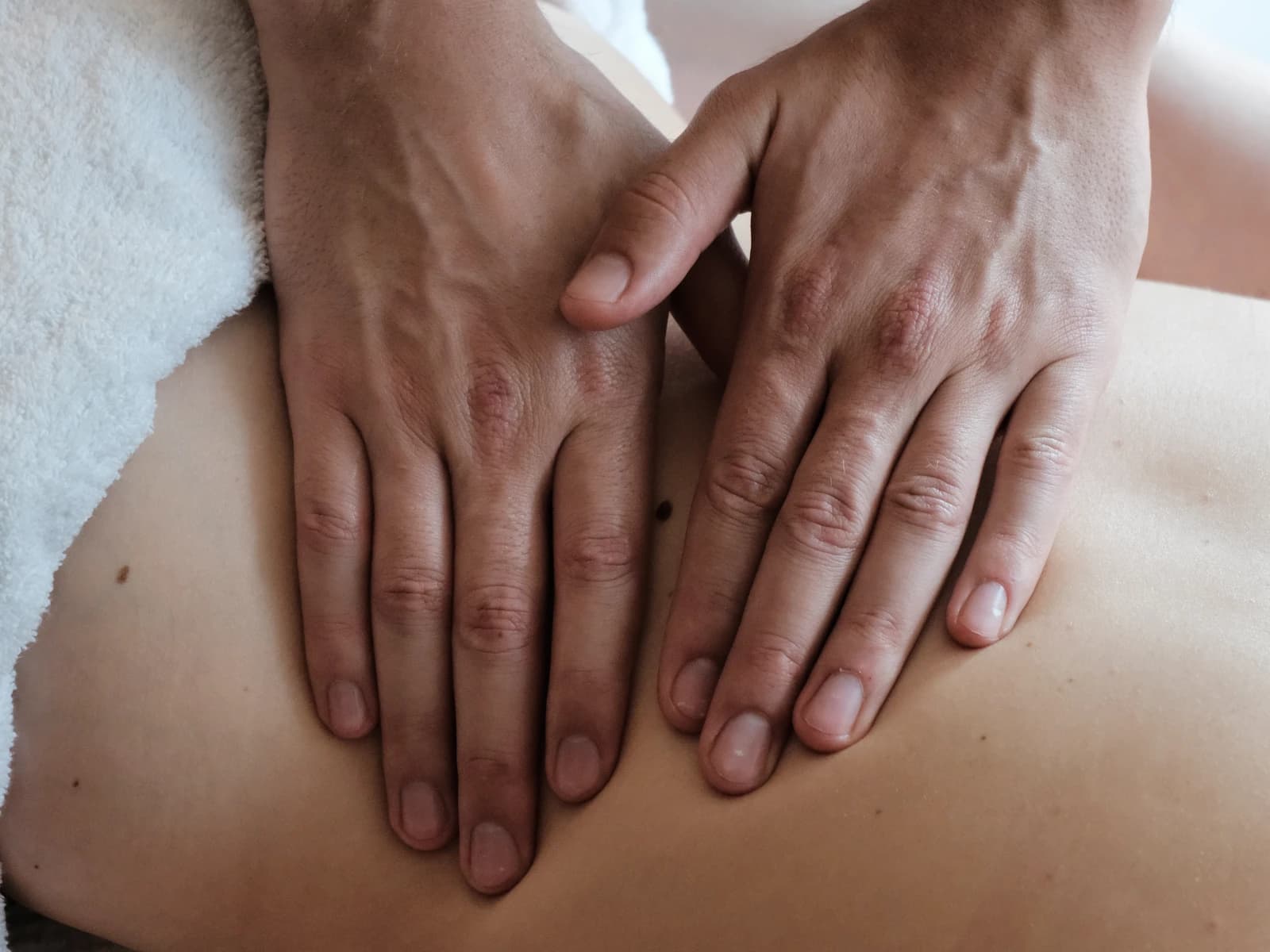 Detailaufnahme der Hände bei einer Rückenmassage